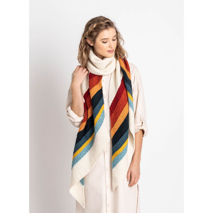 woman wearing the gresham shawl in rainbow colors