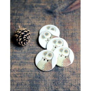 ceramic owl buttons on a wood table