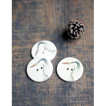 Ceramic stork buttons on a table