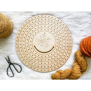 Circle loom with scissors and a hank of yarn