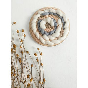 an example of a completed circular loom hanging on a wall
