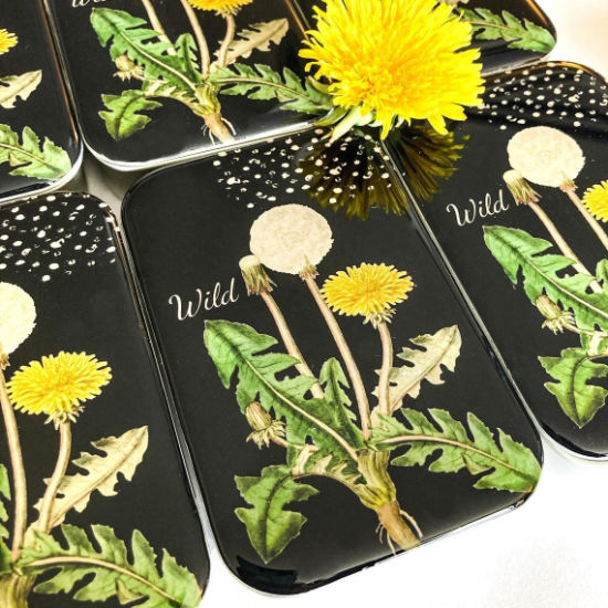 Dandelion notion tin with a black background and pops of yellow