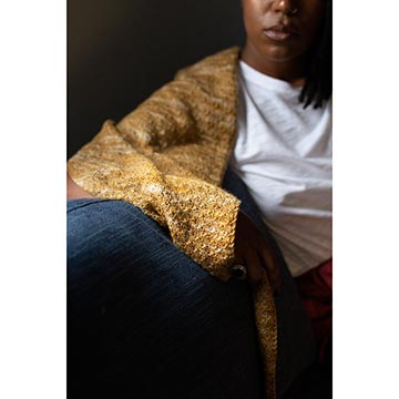 woman sitting on a couch wearing Fino shawl
