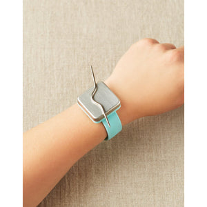 person wearing the makers keep bracelet with a cable needle