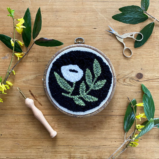 Black Floral Punch needle kit with a wood background