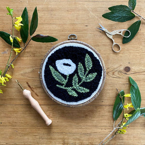 Black Floral Punch needle kit with a wood background